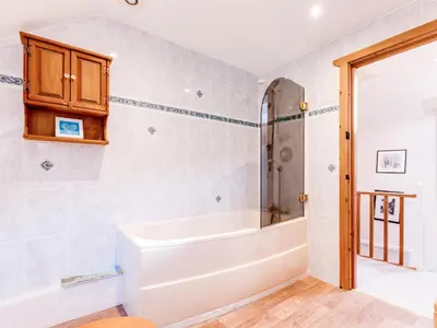 a bathroom with a tub and a shower at Temple Cottage in Port Isaac