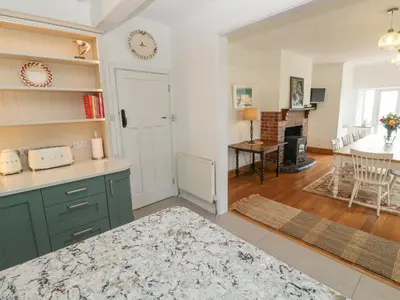 a kitchen and dining room with green cabinets and a table at Penmarth House in Helston