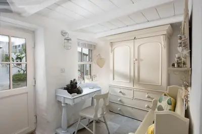 a room with a dresser and a table and chairs at Carvossa - Sea Views & Woodburner in Marazion