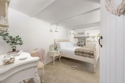 a white bedroom with a bed and a white desk at Carvossa - Sea Views & Woodburner in Marazion