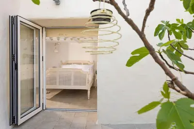 a bedroom with a bed through a glass door at Carvossa - Sea Views & Woodburner in Marazion