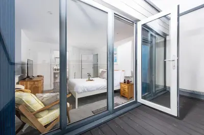 a room with sliding glass doors leading to a bedroom at Kingsley House - Free Parking & WiFi - Close to Newquay's Beaches in Newquay