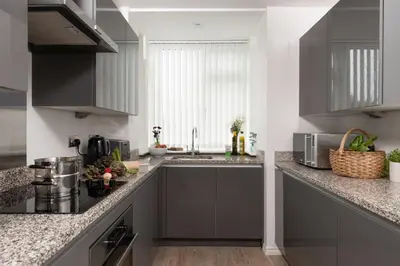 a kitchen with gray cabinets and a sink at Kingsley House - Free Parking & WiFi - Close to Newquay's Beaches in Newquay