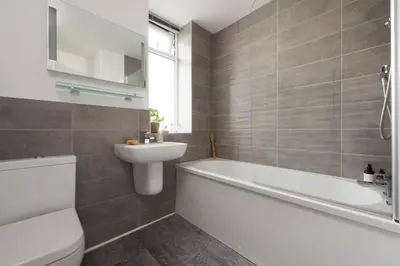a bathroom with a white tub and a sink at Kingsley House - Free Parking & WiFi - Close to Newquay's Beaches in Newquay