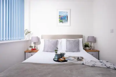a bedroom with a bed with a tray of food on it at Kingsley House - Free Parking & WiFi - Close to Newquay's Beaches in Newquay