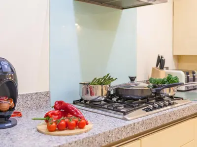 a kitchen counter with a stove with vegetables on it at Golden Sands in St Ives