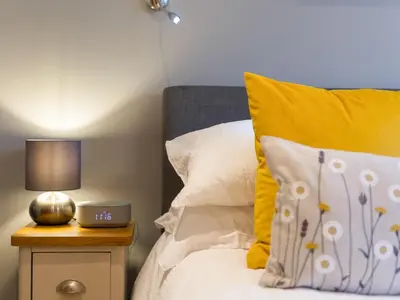 a bedroom with a bed with yellow and white pillows at Golden Sands in St Ives
