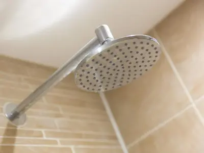 a shower head in a bathroom with a tile floor at Golden Sands in St Ives