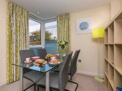 a dining room with a glass table and chairs at Golden Sands in St Ives