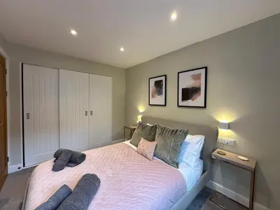 a bedroom with a large bed with two pillows at Primrose in Bodmin