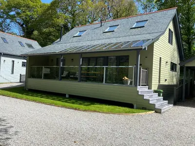 a house with a porch and a house with windows at Primrose in Bodmin
