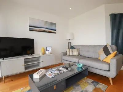 a living room with a couch and a flat screen tv at 5 Quay Court in Newquay