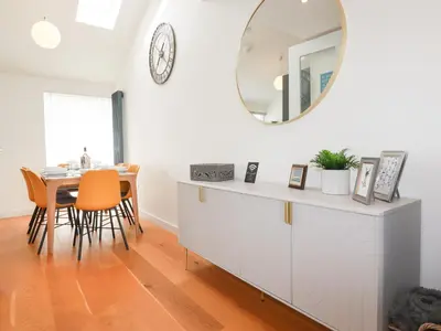 a dining room with a table and a mirror at 5 Quay Court in Newquay