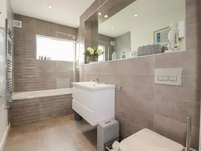 a bathroom with a toilet and a sink and a shower at 5 Quay Court in Newquay