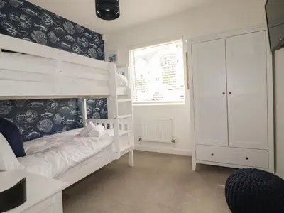 a bedroom with a white bunk bed and a window at 5 Quay Court in Newquay