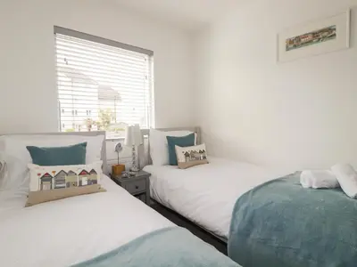 a bedroom with two beds and a window at 5 Quay Court in Newquay