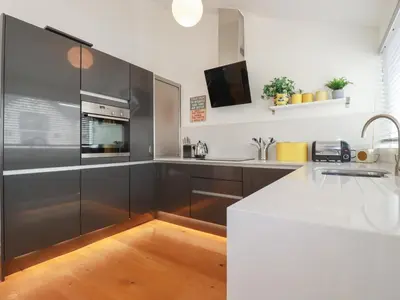 a kitchen with black and white cabinets and a sink at 5 Quay Court in Newquay