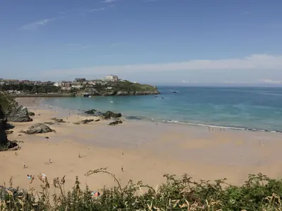 a beach with a group of people in the water at 5 Quay Court in Newquay