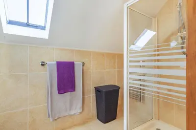 a bathroom with a shower and a purple towel at Miller's Lodge in Liskeard