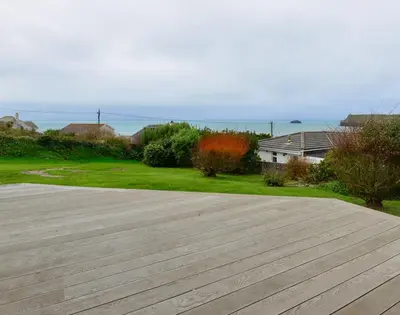 a large wooden patio with a view of the ocean at Sea Mist in Polzeath