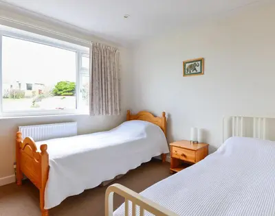 a bedroom with two beds and a window at Sea Mist in Polzeath
