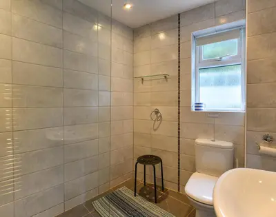 a bathroom with a toilet and a sink and a window at Sea Mist in Polzeath