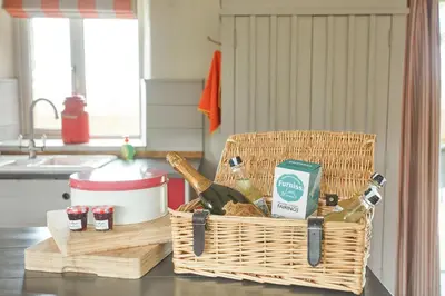 a basket of food and wine on a kitchen counter at Meadow View in Newquay