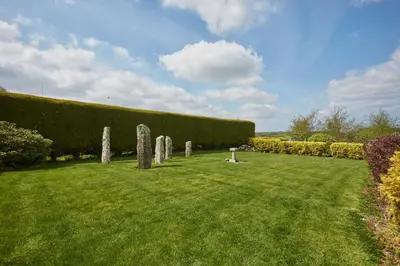 a grassy field with a row of stone statues at Meadow View in Newquay