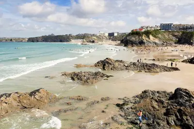 a group of people on a beach with rocks at Meadow View in Newquay