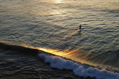 a person riding a wave on a surfboard in the ocean at Meadow View in Newquay