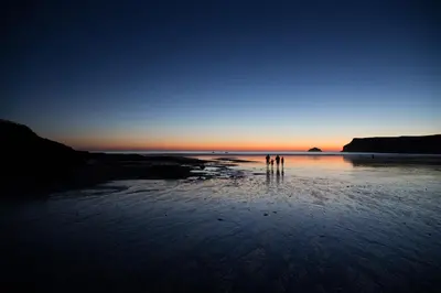 two people standing on the beach at sunset at Brookside in Polzeath