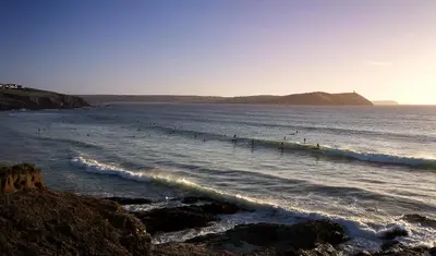 a group of people surfing in the ocean at Brookside in Polzeath