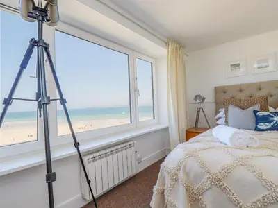 a tripod in a bedroom with a view of the beach at Men an Mor in St Ives