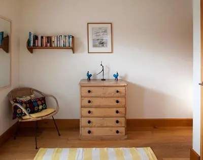 a dresser in a room with a chair at Ossco in Polzeath