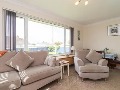 a living room with a couch and two chairs at Tremethic in St Austell