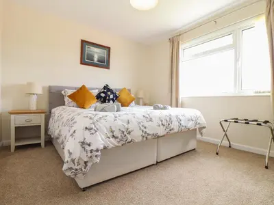 a bedroom with a large bed with a window at Tremethic in St Austell