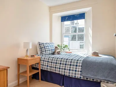 a small bedroom with a bed and a window at Trevivian House in Boscastle