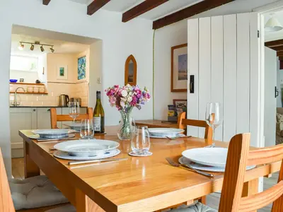 a dining room with a wooden table with a vase of flowers at Trevivian House in Boscastle