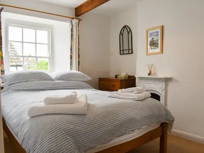 a bedroom with a bed with two towels on it at Trevivian House in Boscastle