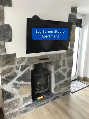 a fireplace with a flat screen tv above it at Ocean View Apartments in Looe