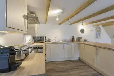 a kitchen with white cabinets and a counter top at Kelmscot in Port Isaac