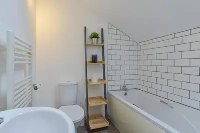a bathroom with a tub and a toilet and a sink at Kelmscot in Port Isaac