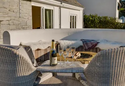 a bottle of wine sitting on a table with two glasses at Landers Field in Padstow