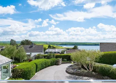 a driveway leading to a house with a view of a lake at Landers Field in Padstow