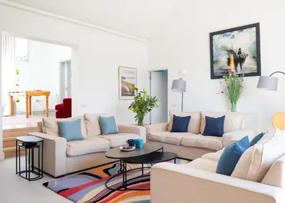 a living room with white furniture and blue pillows at Landers Field in Padstow