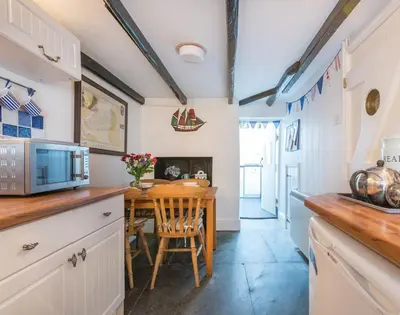 a kitchen with a table and a dining room at Cloam Cottage in Port Isaac