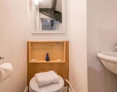 a bathroom with a toilet and a sink and a mirror at Cloam Cottage in Port Isaac