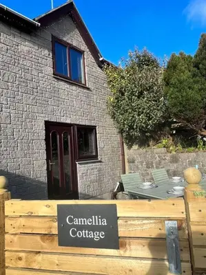 a sign on a fence in front of a house at Camellia Cottage in Camborne