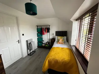 a bedroom with a bed with a yellow blanket at Camellia Cottage in Camborne
