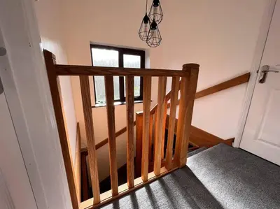 a wooden staircase in a room with a window at Camellia Cottage in Camborne